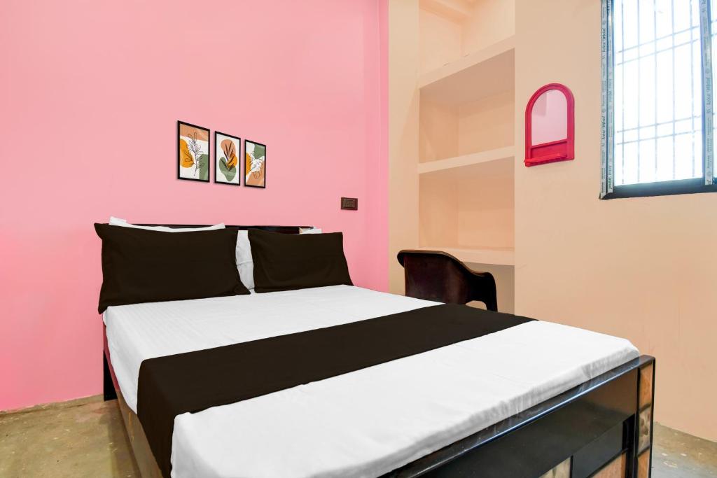 Cama en habitación con pared de color rosa en Hotel O Welcome Guest House, en Patna