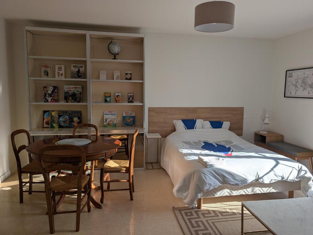 ein Schlafzimmer mit einem Bett, einem Tisch und einem Schreibtisch in der Unterkunft Joli appartement cœur de ville in Poitiers