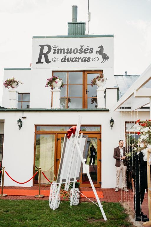 a man standing in front of a building at Rimuošės dvaras in Šniūraičiai