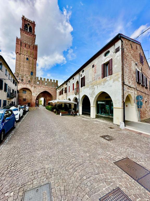 a cobblestone street with a building and a clock tower at Casa Sorgata in Noale