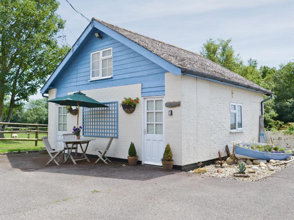 a blue and white house with a table and umbrella at The Blue Loft in Rye
