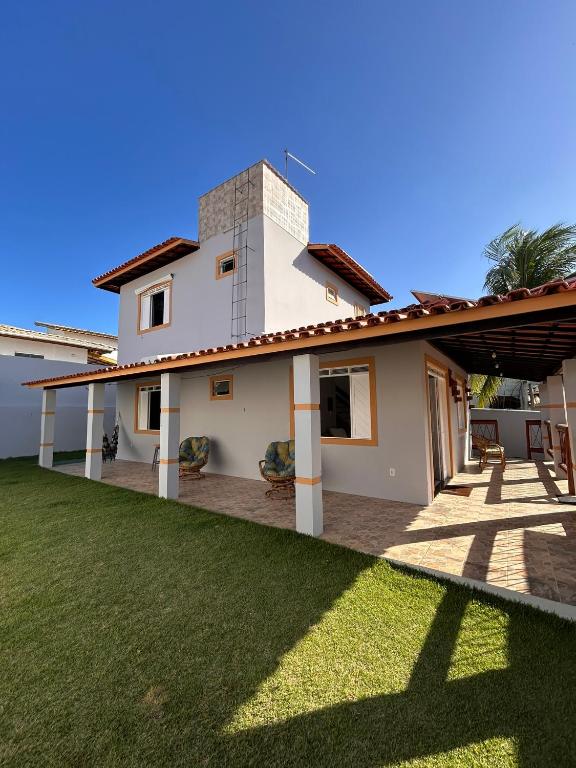 a house with a lawn in front of it at Casa 10 com piscina em Jacuípe - Guarajuba in Camaçari