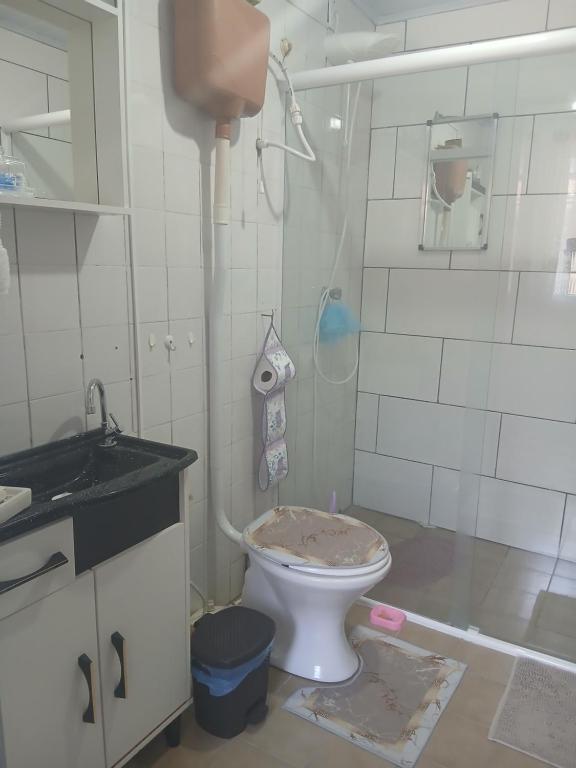 a bathroom with a toilet with a sink and a shower at Casa da Nise in São Gabriel