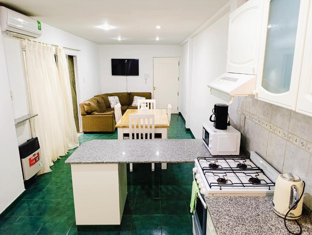 a kitchen and living room with a stove top oven at Amplio departamento en pleno centro con cochera privada in San Rafael