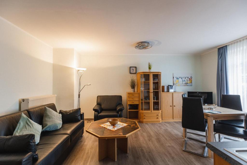 a living room with a couch and a table at Inselglück App 1 in Norderney
