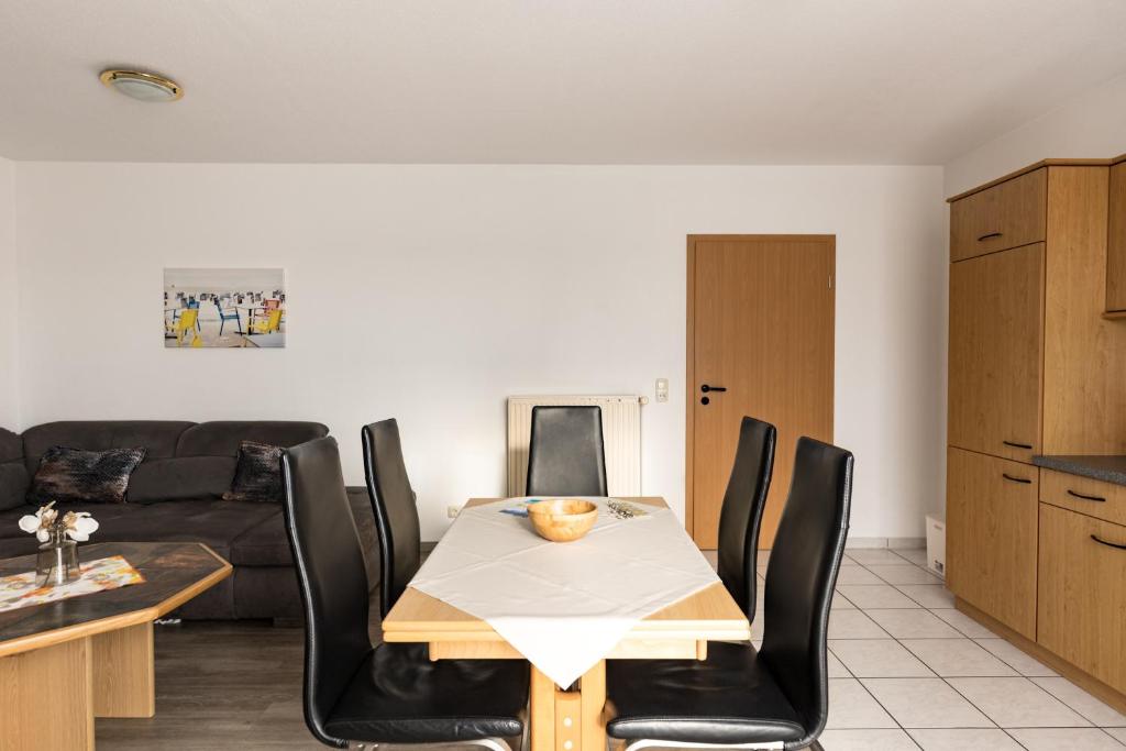 a living room with a table and chairs and a couch at Inselglück App 2 in Norderney
