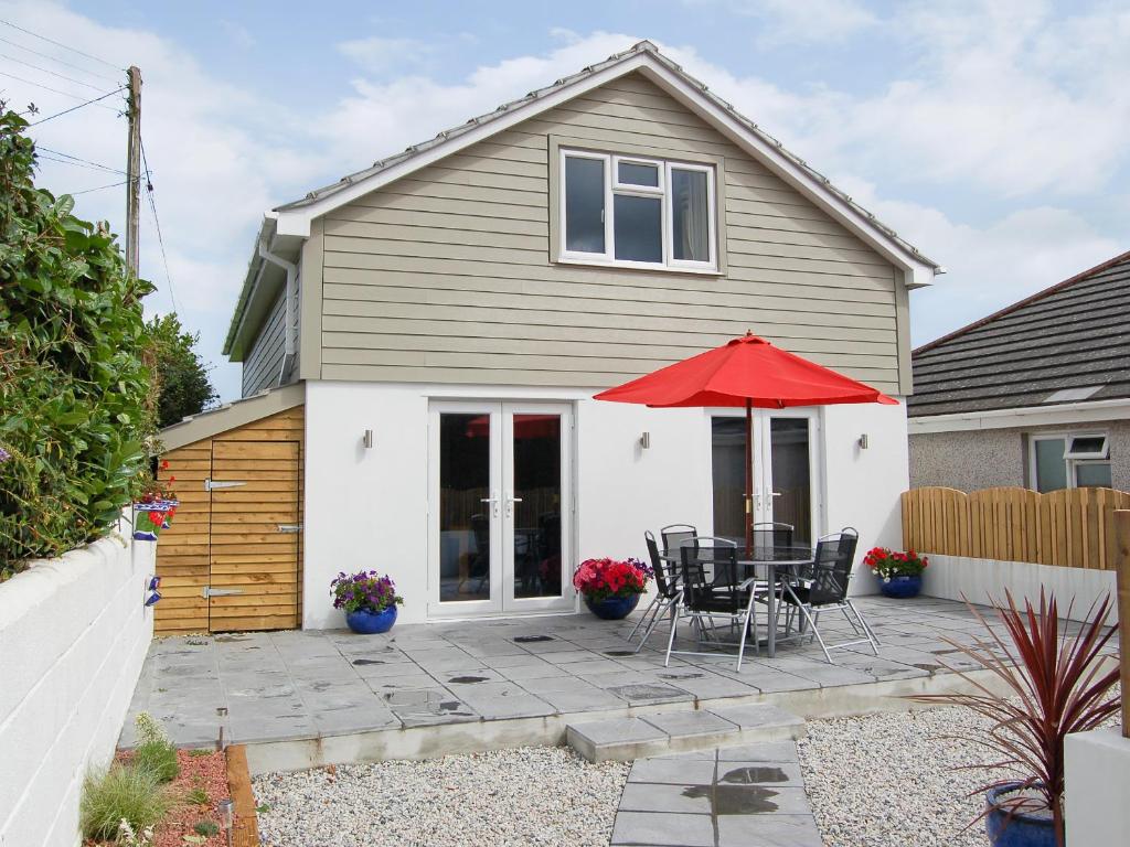 Saint EndellionにあるOwls Parkの赤い傘付きのパティオのある家