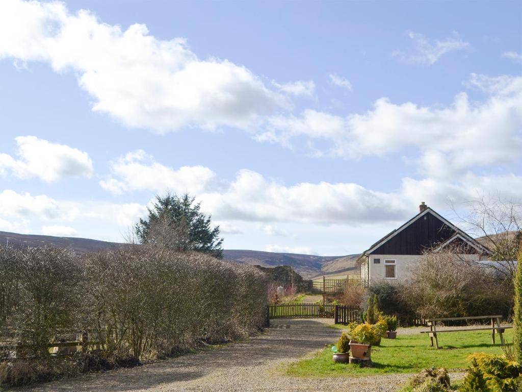 a road leading to a house with a fence at Rowan Cottage-80119 in Catcleugh