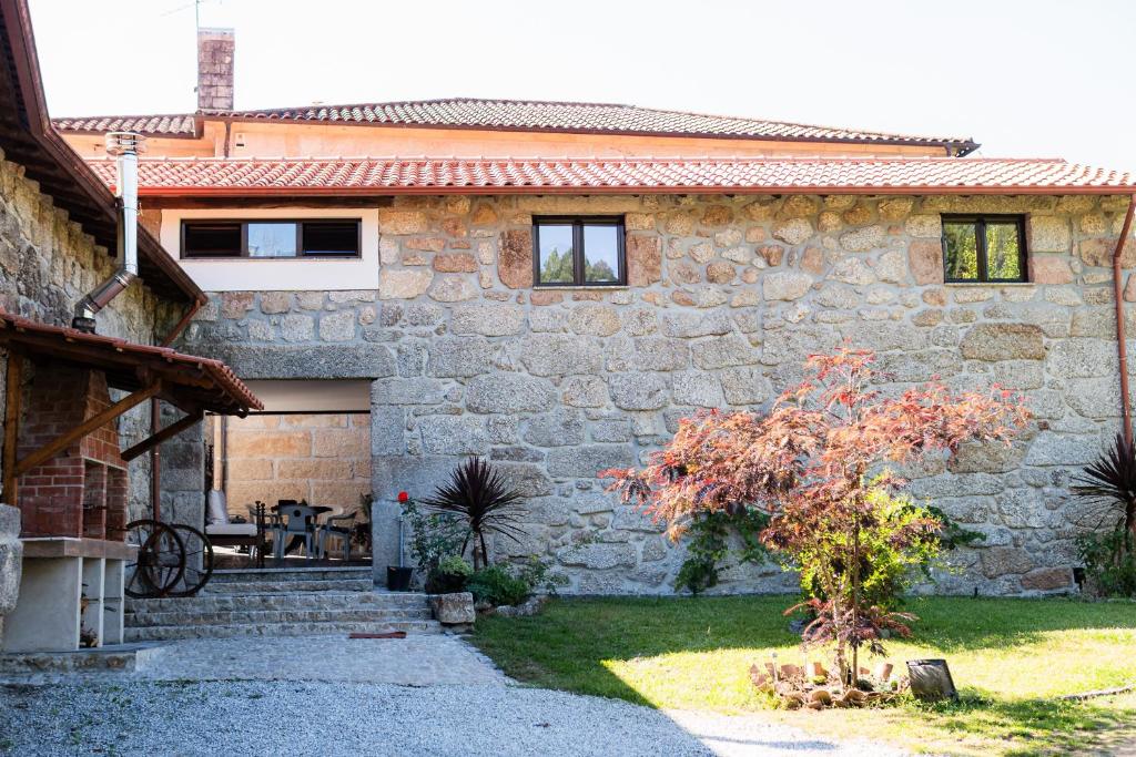 a stone house with a table in a yard at Quinta do Assento in Louredo