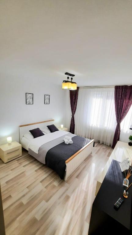 a bedroom with a large bed and a wooden floor at Apartament KEPA din Piatra Neamt in Piatra Neamţ