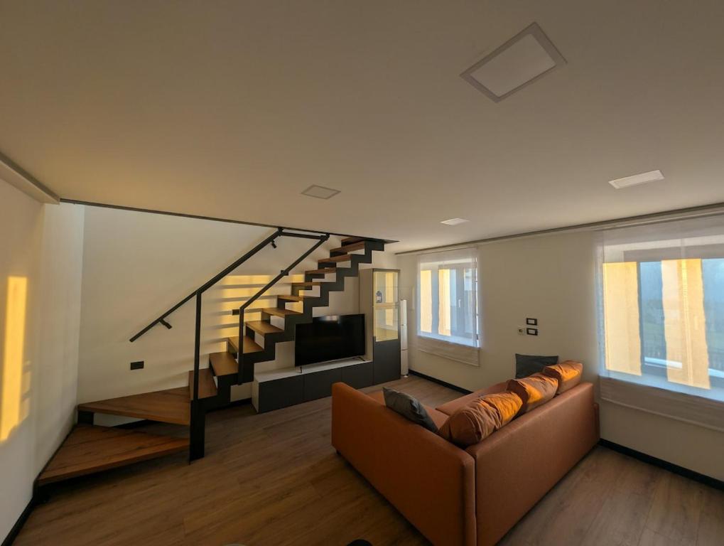 a living room with a couch and a staircase at Appartamento Dar Per in Lavarone
