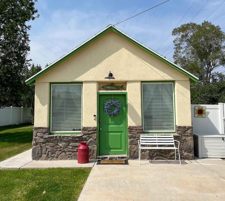 a house with a green door and a bench at The Cottage in Panguitch
