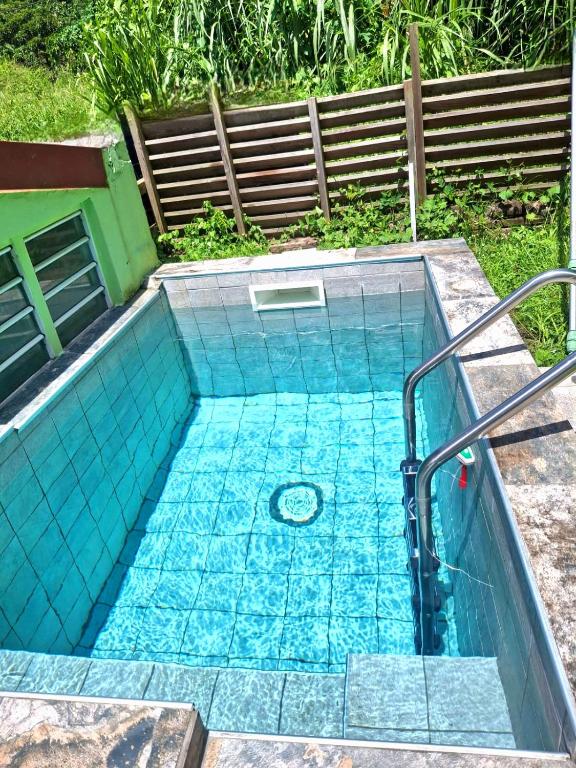 a swimming pool with blue tiles on the ground at L'Orange Volcanique in Saint-Pierre
