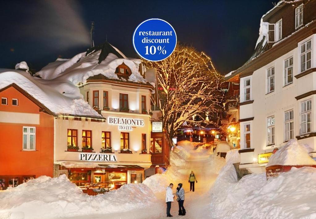 a group of people walking down a snow covered street at Hotel pizzeria Belmonte in Špindlerův Mlýn