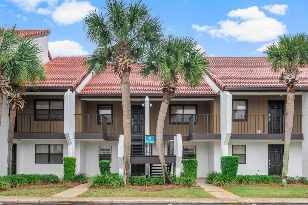 a building with palm trees in front of it at Mermaid's Den in Panama City Beach