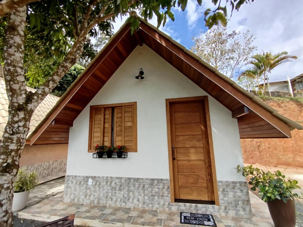a house with a door and a tree at Chalé Sognare Uno in Santa Teresa