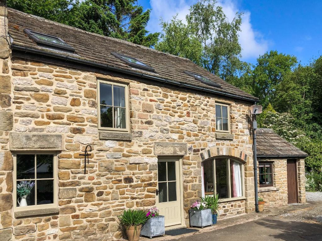 an old stone house with windows and plants on it at Cotton Cottage in Hope