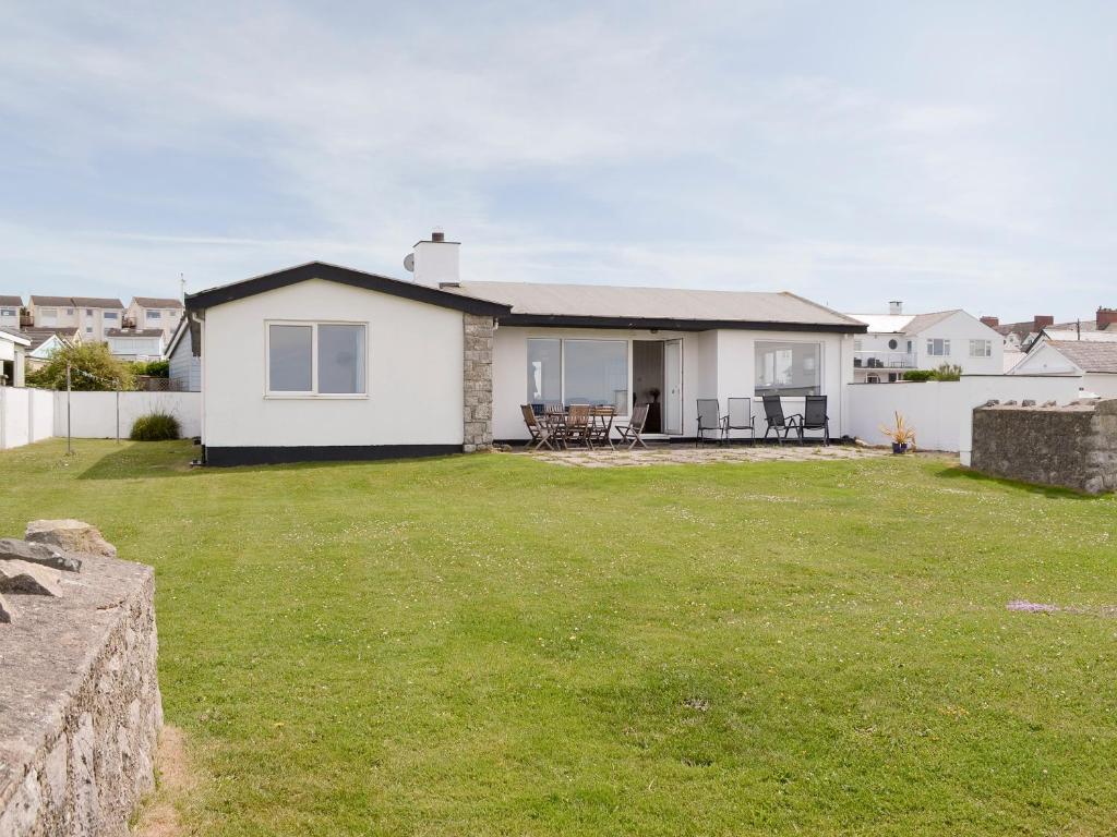 una casa bianca con un prato davanti di West Lawn a Rhosneigr