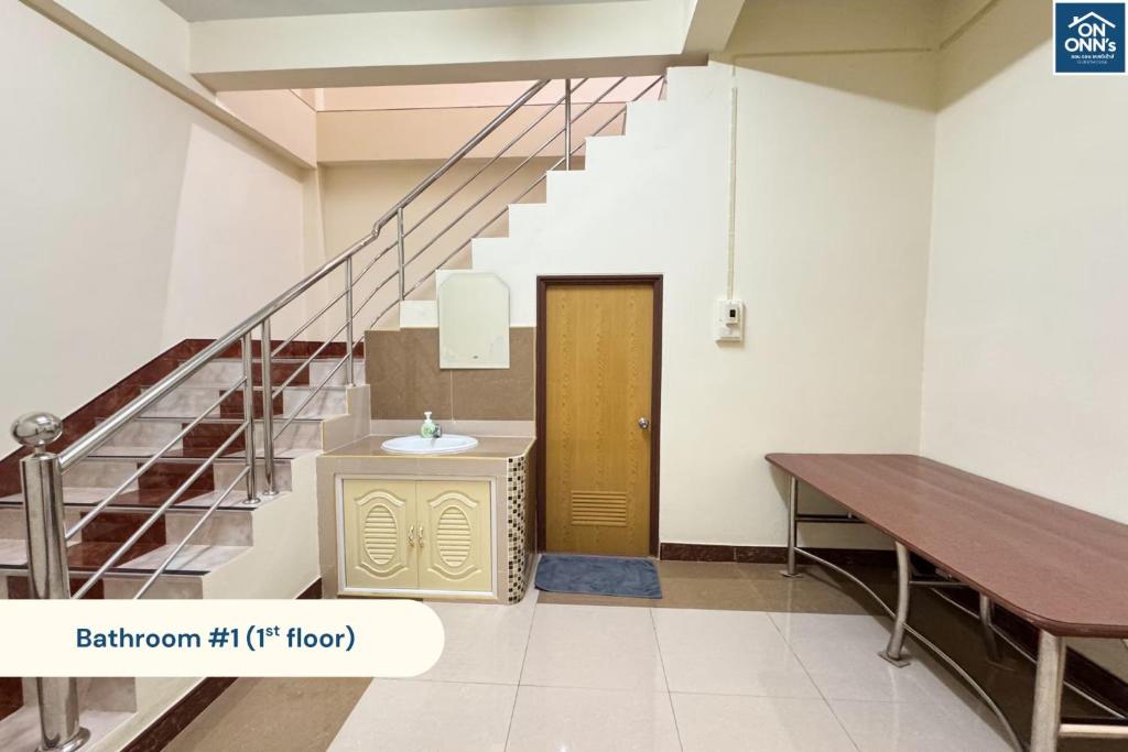 a hallway with a staircase and a wooden door at On Onn's Guesthouse in Ban Komo Sip Paet