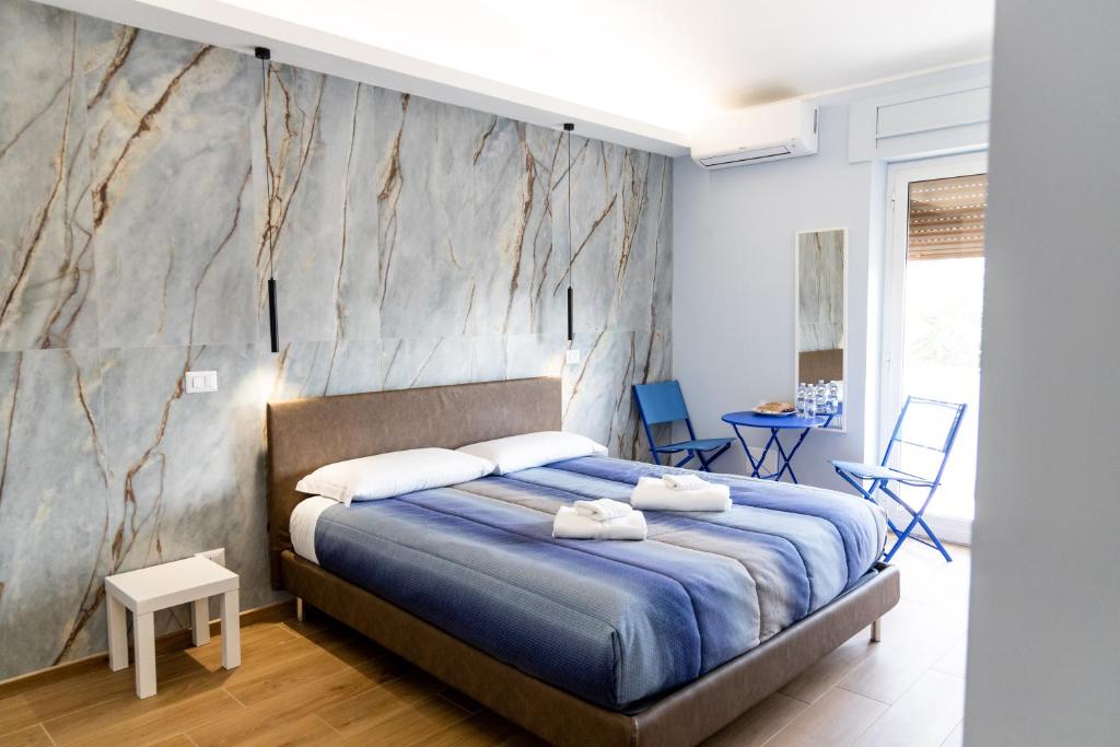 a bedroom with a blue bed and a marble wall at Casa twins in Fiumicino