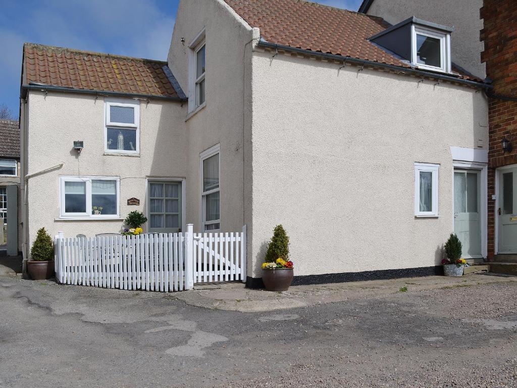a white house with a white picket fence at Rockville Cottage - 24376 in Bempton