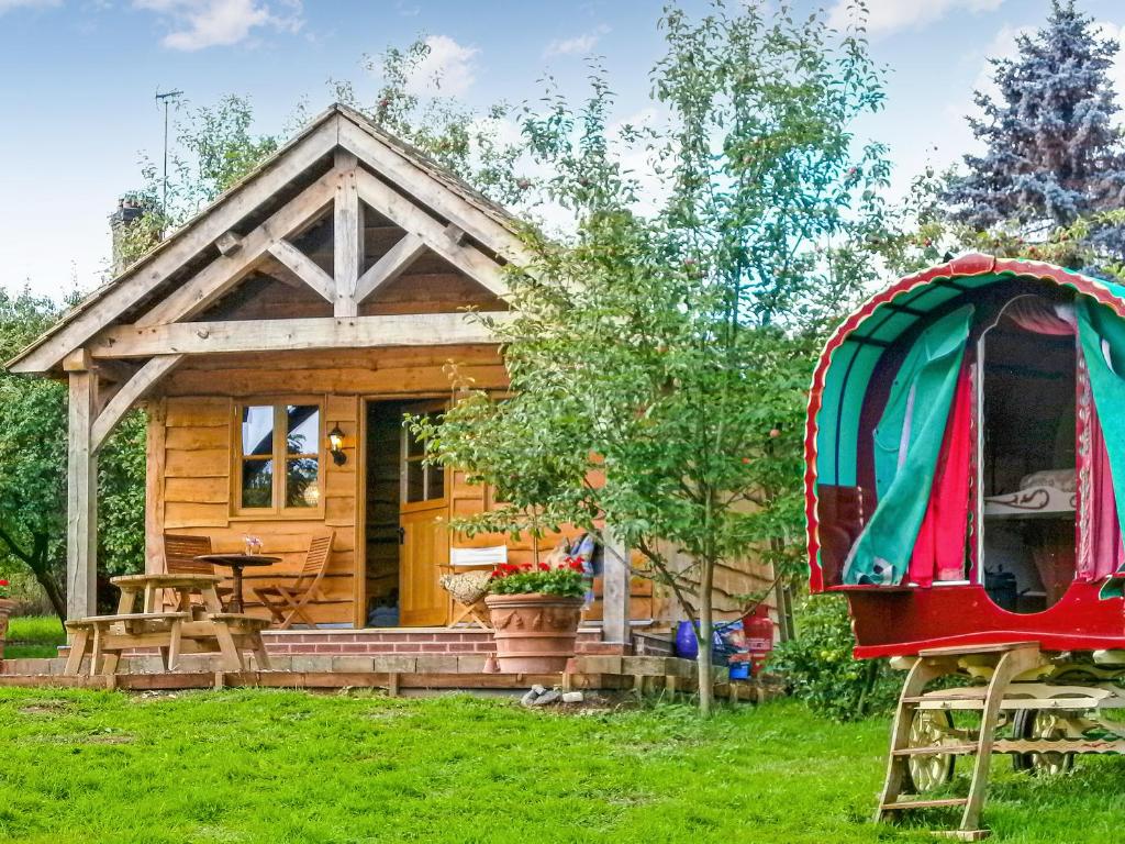 a log cabin with a porch and a gazebo at Copperbeech Bowtop in Tilston