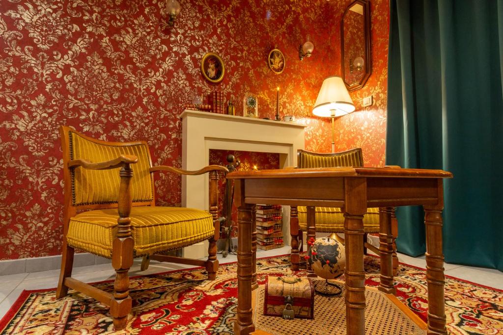 a living room with two chairs and a table and a fireplace at Le Sherlock - Cinéma privé & Enquête in Roanne