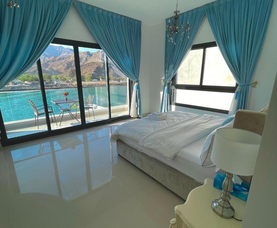 a bedroom with a bed and a view of a pool at Al Dana Palma Villa - Luxury 4-bedroom villa with Heated Pool & Mountain Sea View in Fujairah