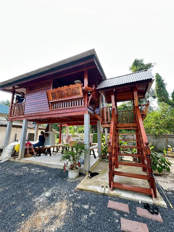 a tree house with a ladder in front of it at Peony brown in Thongsala
