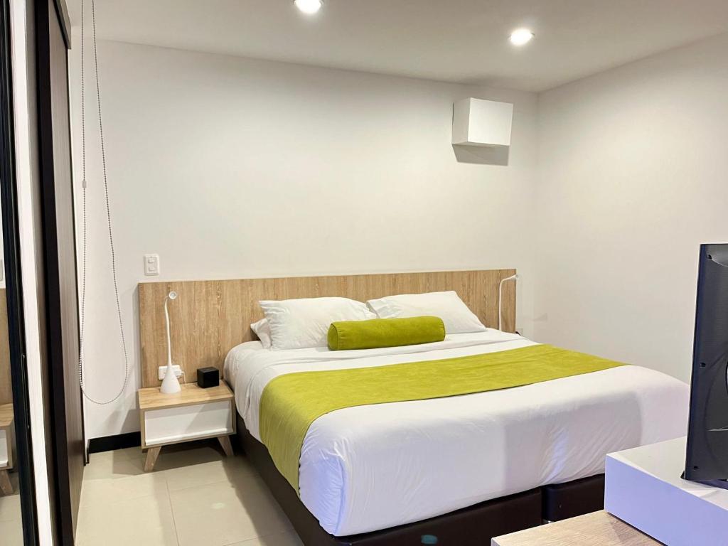a bedroom with a large bed and a television at Apartasuite cercana al aeropuerto internacional MED in San Antonio de Pereira