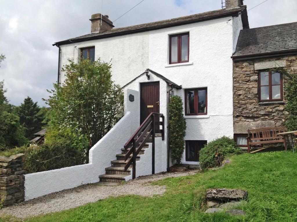 an external view of a white house with stairs at Rock Cottage in Crosthwaite