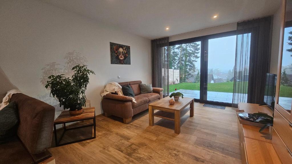un soggiorno con un divano e un tavolo di Wallys Auszeit a Grub am Forst