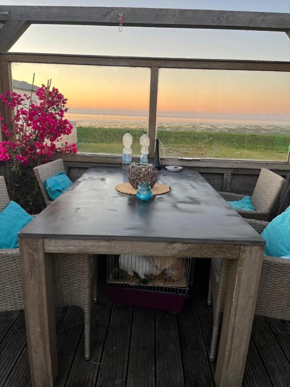 a table on a deck with a view of the ocean at Luxus Chalet Wattenmeerblick in Westerland