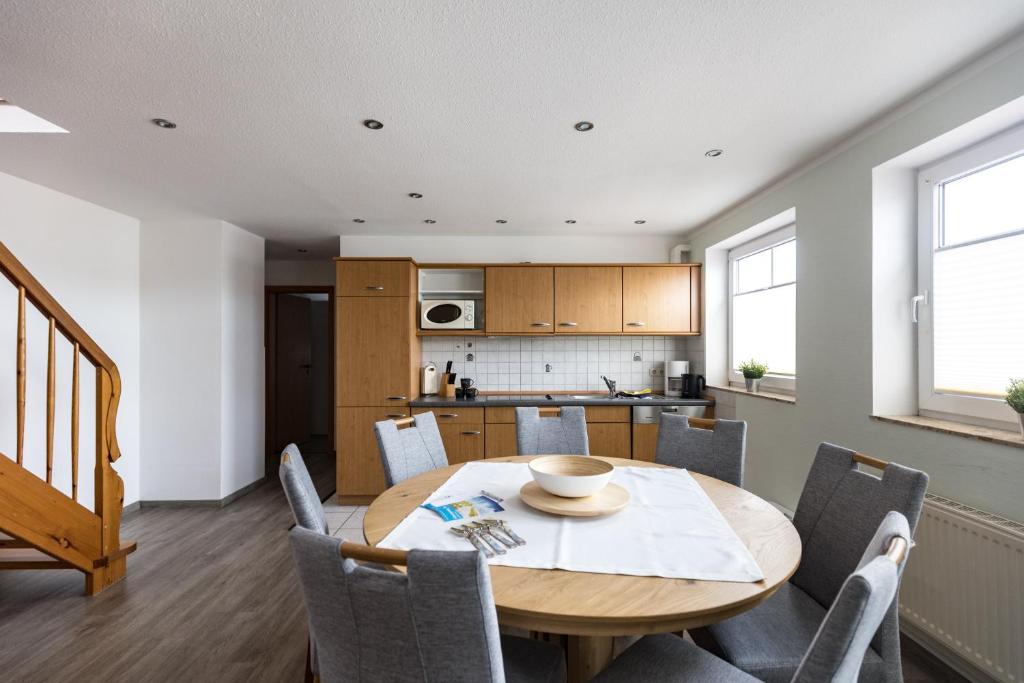 a kitchen and dining room with a wooden table and chairs at Inselglück App 4 in Norderney