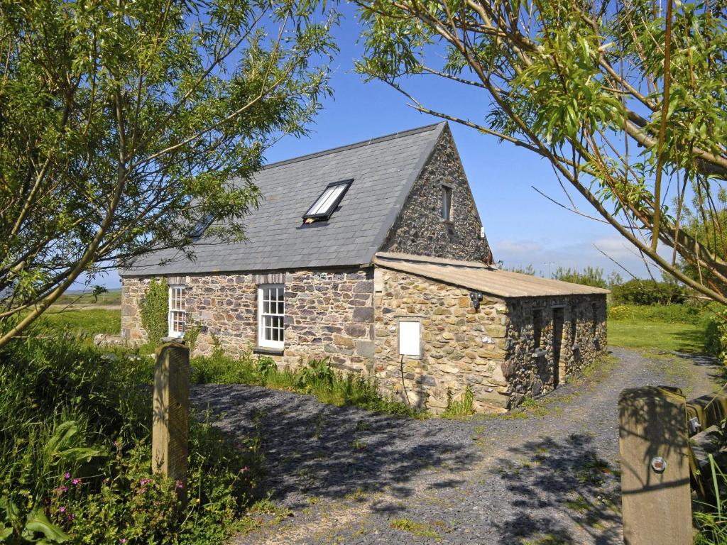 an old stone church in the middle of a field at Rhosson Chapel Cottage in St. Davids