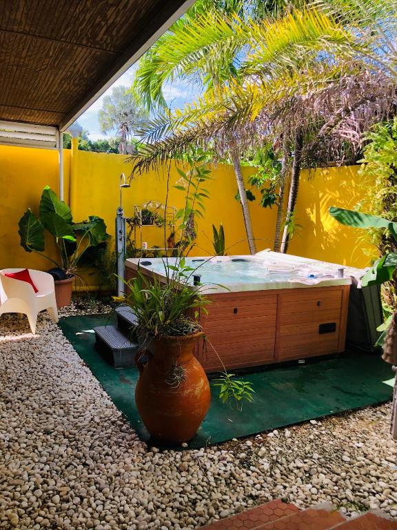 a bedroom with a large bed with plants in it at Joli oasis au centre de l'île in Baie-Mahault
