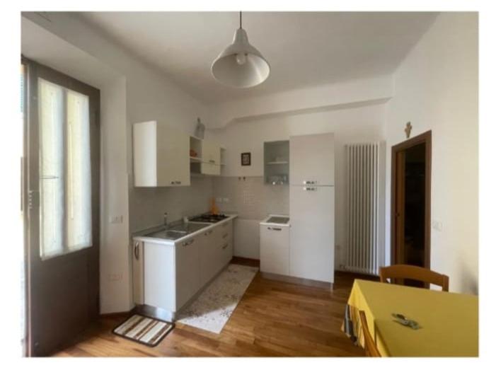 a kitchen with white cabinets and a table and a window at In Centro a Senigallia in Senigallia