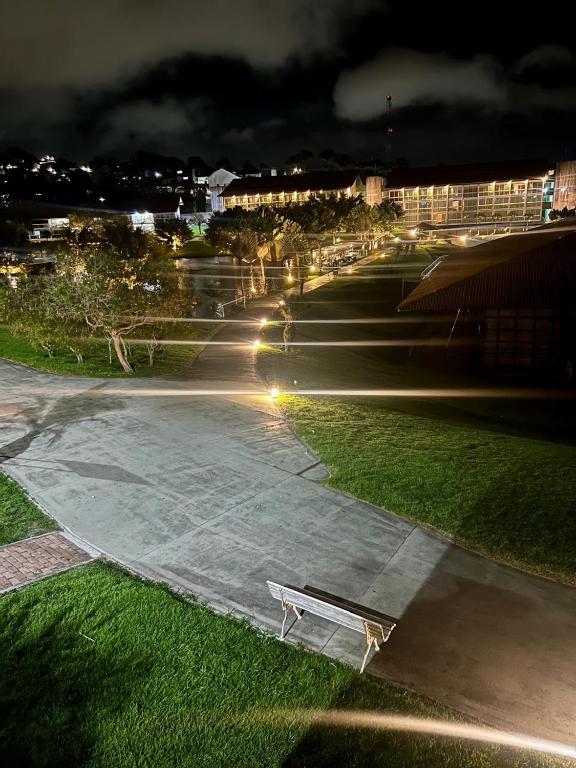 a bench sitting on a sidewalk in a park at night at Flat 718, Villa hípica, Gravatá in Gravatá