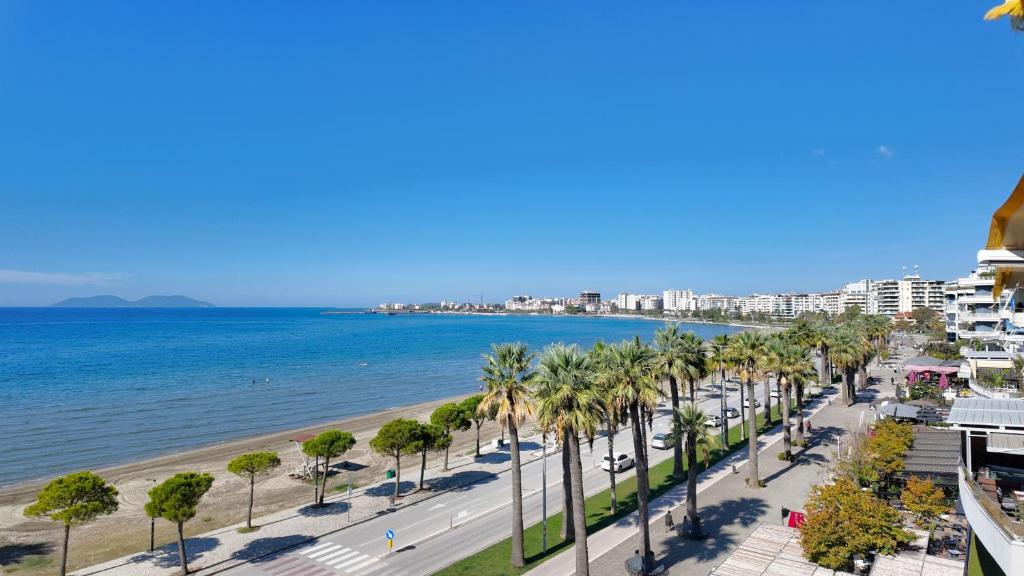 a view of a beach with palm trees and buildings at Casa sul Mare in Vlorë