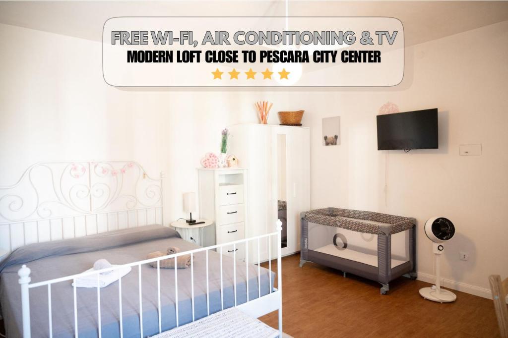 a baby room with a crib and a tv at Loft Grazioso - Pescara in Pescara
