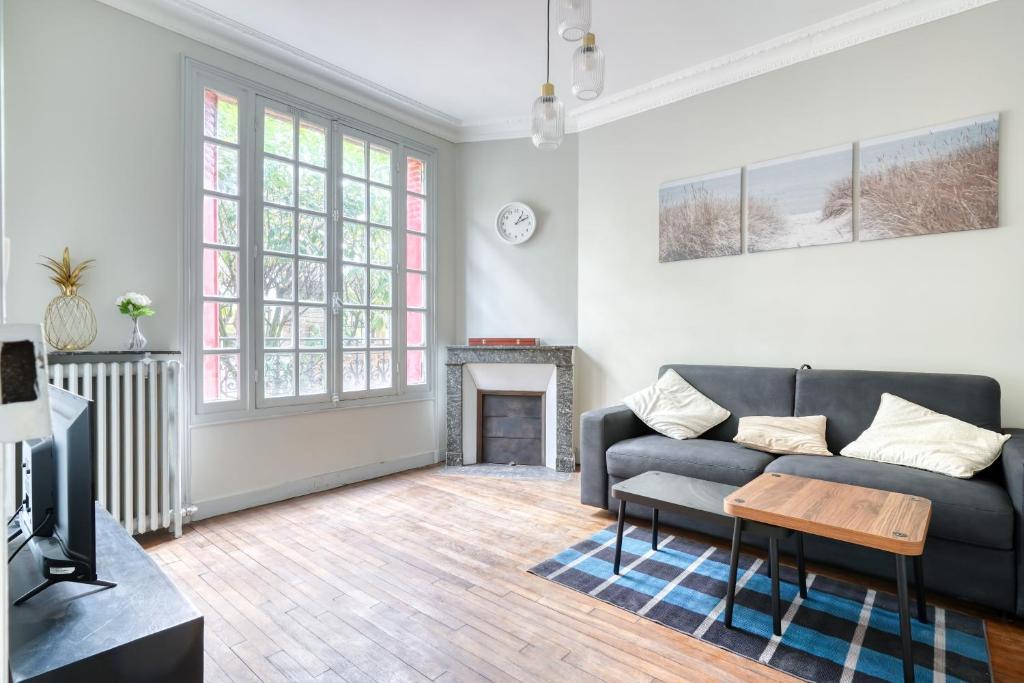 a living room with a couch and a fireplace at Maison familiale proche Paris et transport 8 personnes in Maisons-Alfort