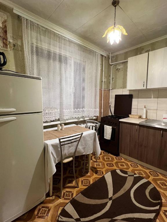 eine leere Küche mit einem Tisch und einem Kühlschrank in der Unterkunft Апартаменти Клосовського in Schytomyr