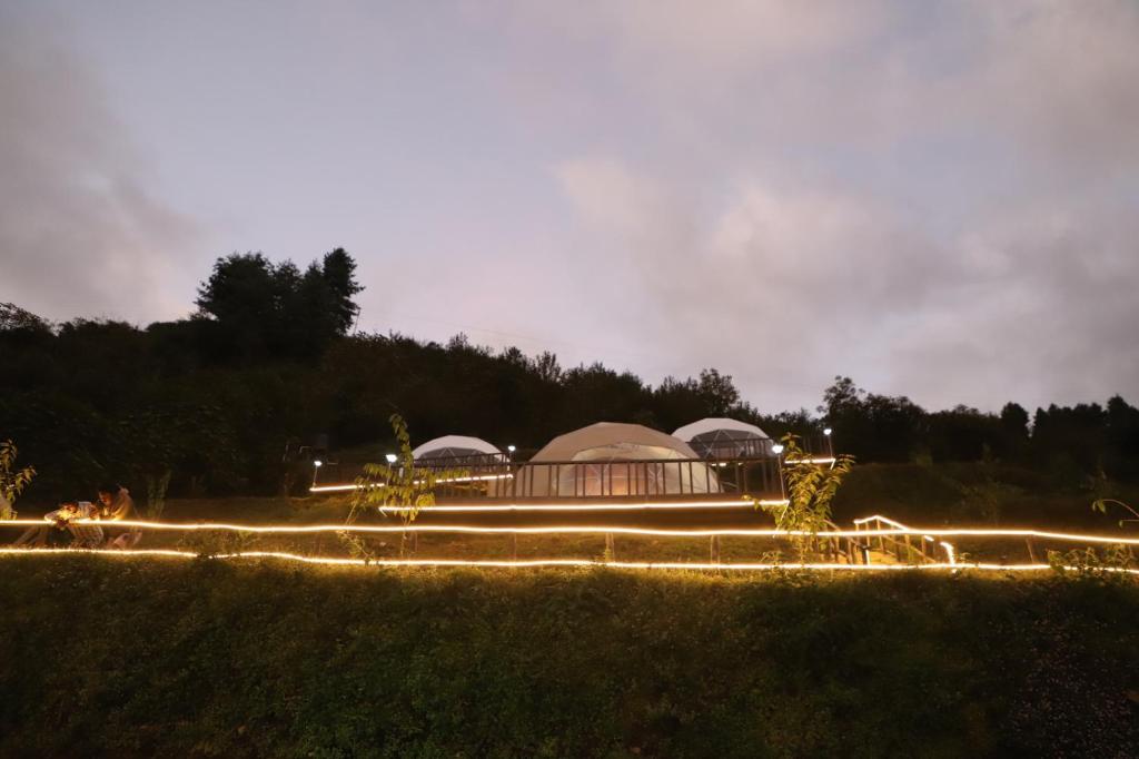 a building with domes with lights in a field at The Kamcha Geodesic dome & Homestay in Bomdila