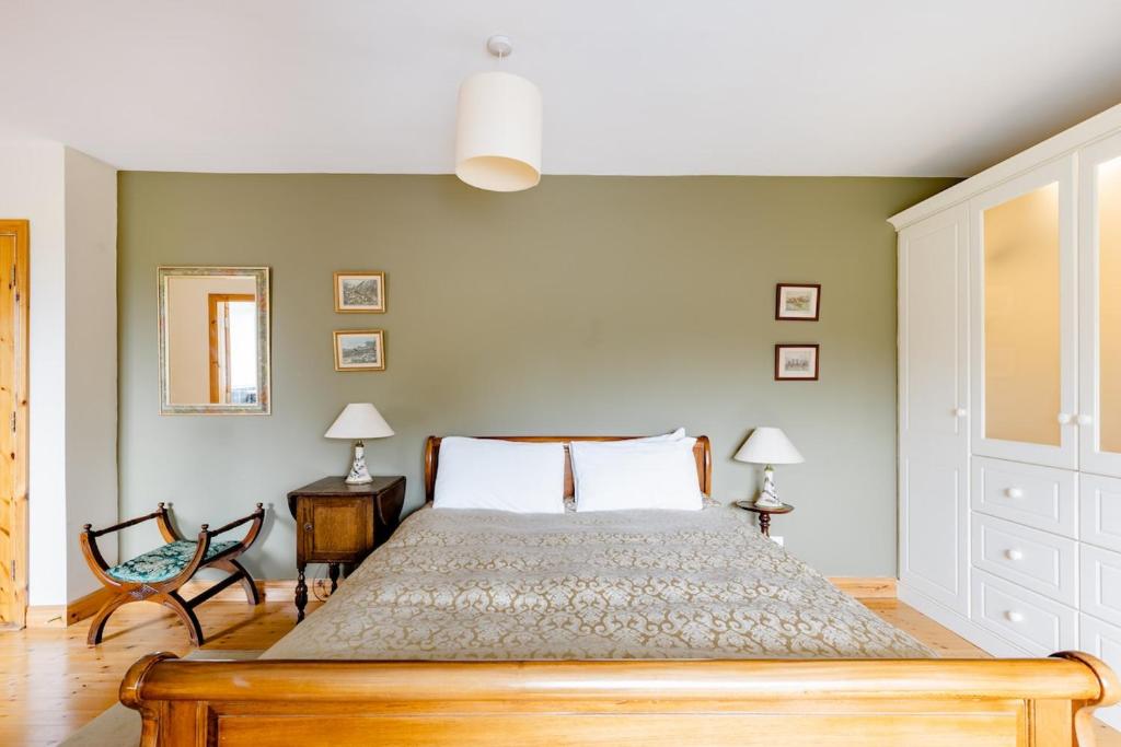 Un dormitorio con una cama y dos sillas y un espejo. en Cuileann, en Clarinbridge