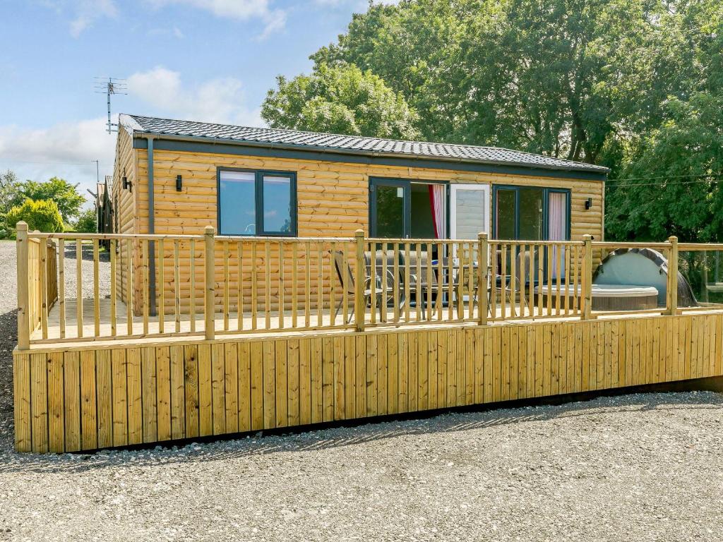 a wooden tiny house with a wooden deck at Hill Crest Lodge 1 in Hemswell