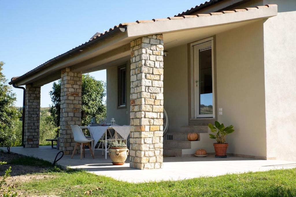 a patio of a house with a roof at Il giardino di Magliano in Magliano in Toscana