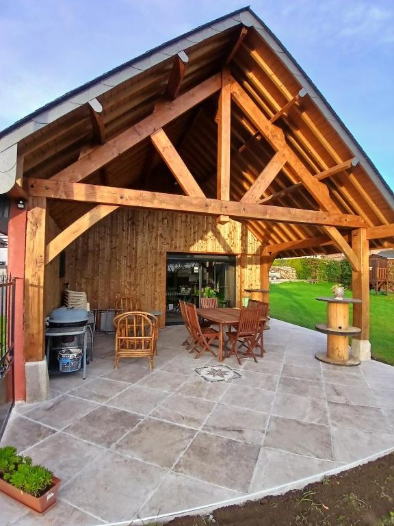 a pavilion with a table and chairs on a patio at Le gîte Normand in Saint-Vaast-dʼÉquiqueville