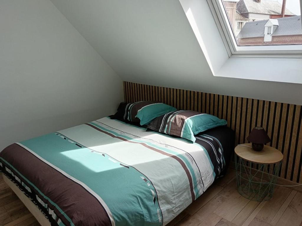 Posto letto in una piccola camera con finestra di Le gîte Normand a Saint-Vaast-dʼÉquiqueville