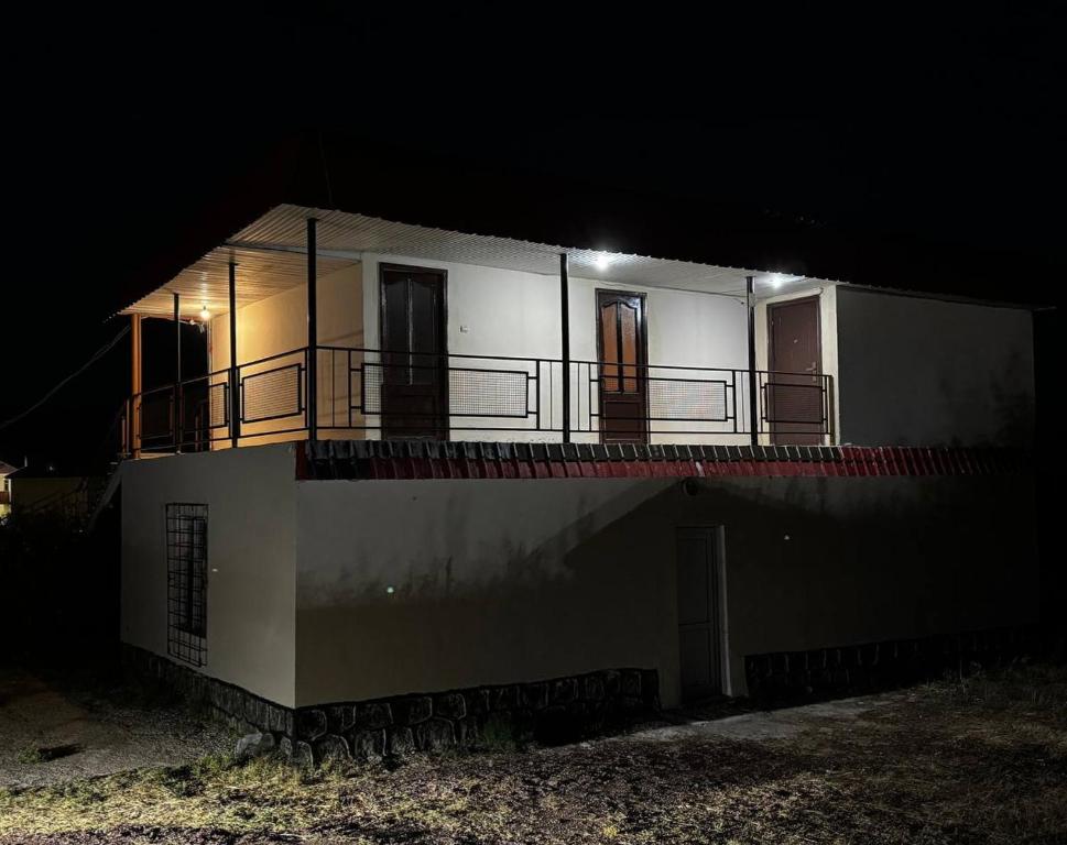 una casa blanca con balcón por la noche en Moon inn Sevan Resort, en Sevan