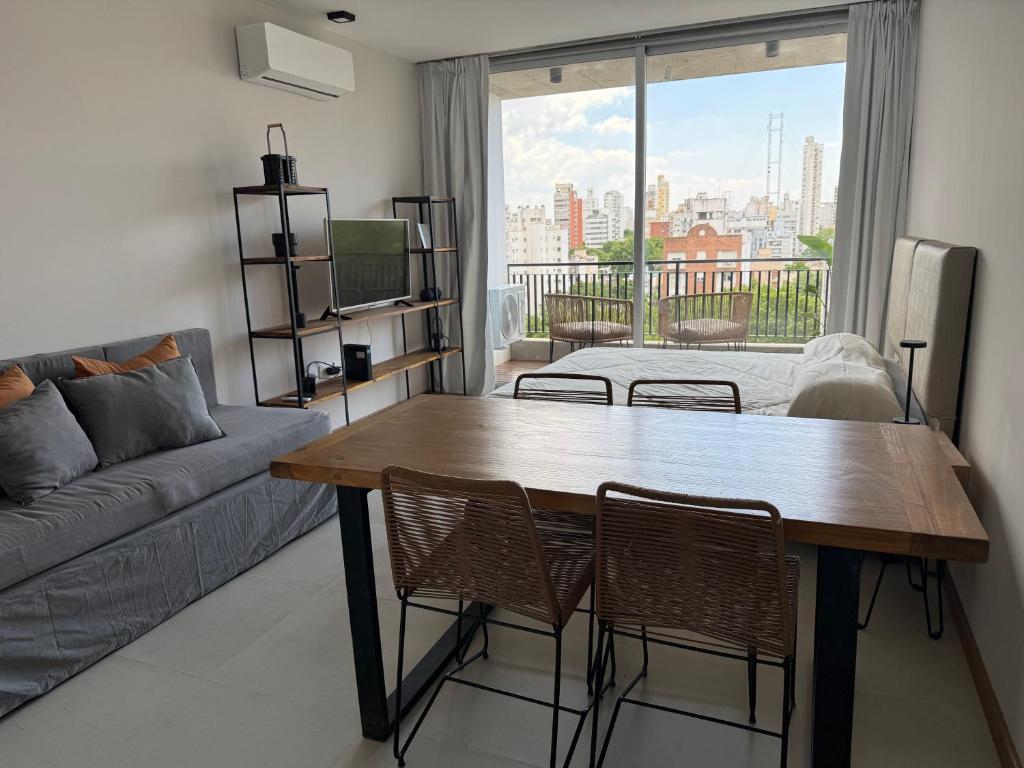 a living room with a table and chairs and a couch at Departamento Estudio Deluxe in La Plata